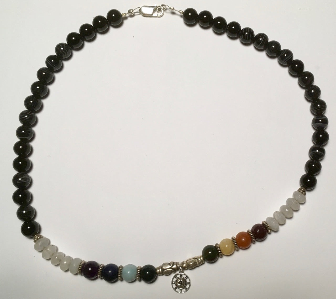 Chakra Collier mit allen Farben der Chakras und des Farbspektrums, kombiniert mit Silberteilen und einem kleinen Om in der Mitte. 